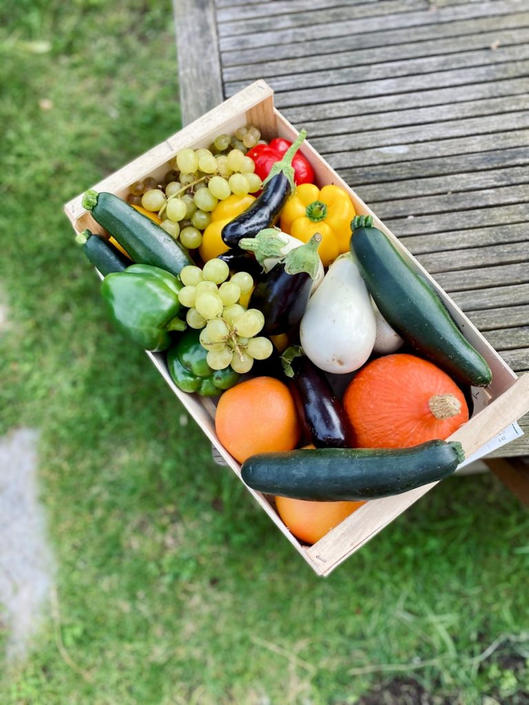 a wooden crate filled with assorted fruits and vegetables
